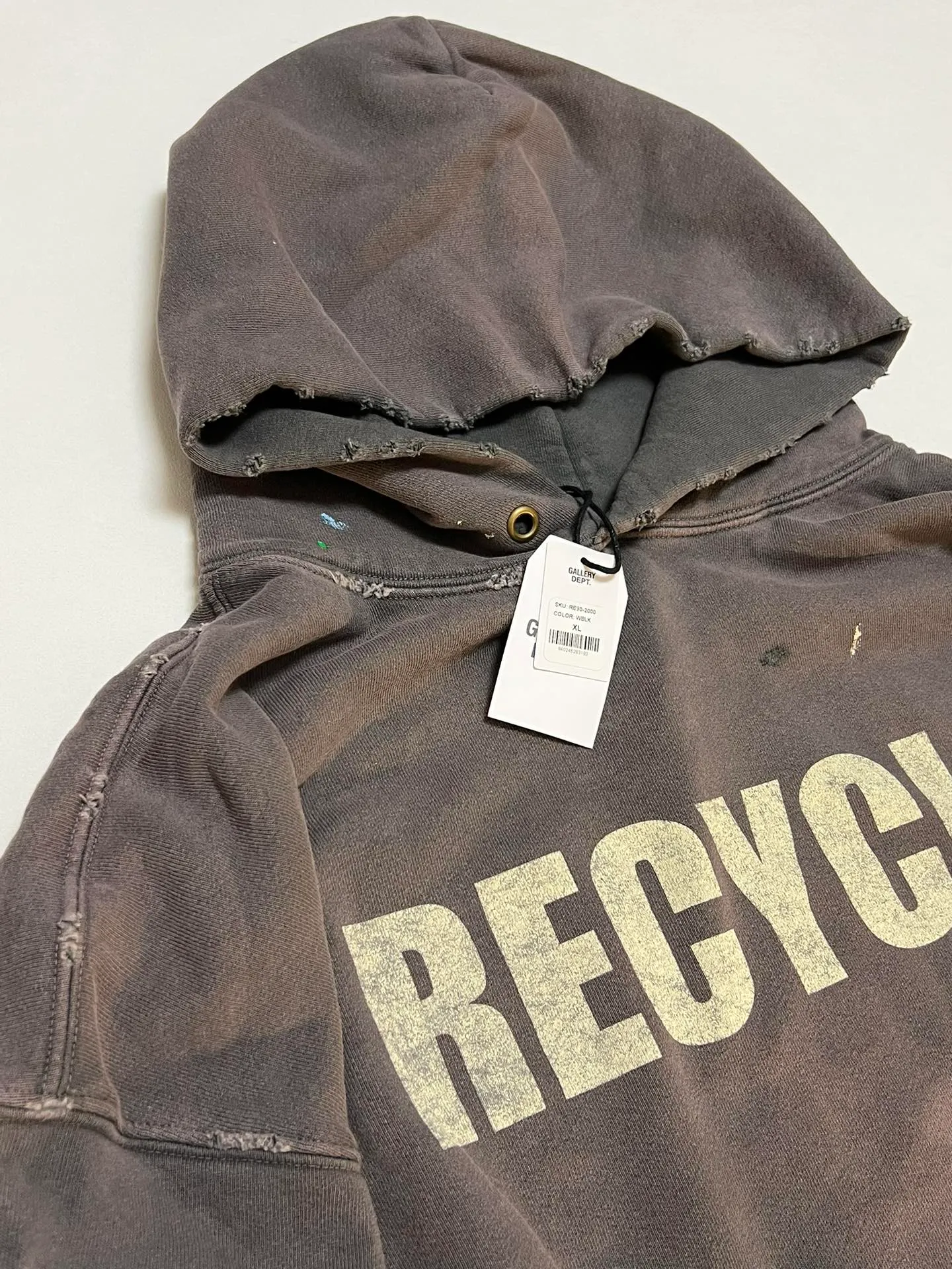 GALLERY DEPT. 90'S RECYCLE HOODIE WASHED BLACK 90'S washed hoodie with distressed eco-friendly slogans. Washed black S-XL. Ready-made garments are washed and dyed again. Multiple spots throughout the body are spray-faded. The ribs are cut and worn.
